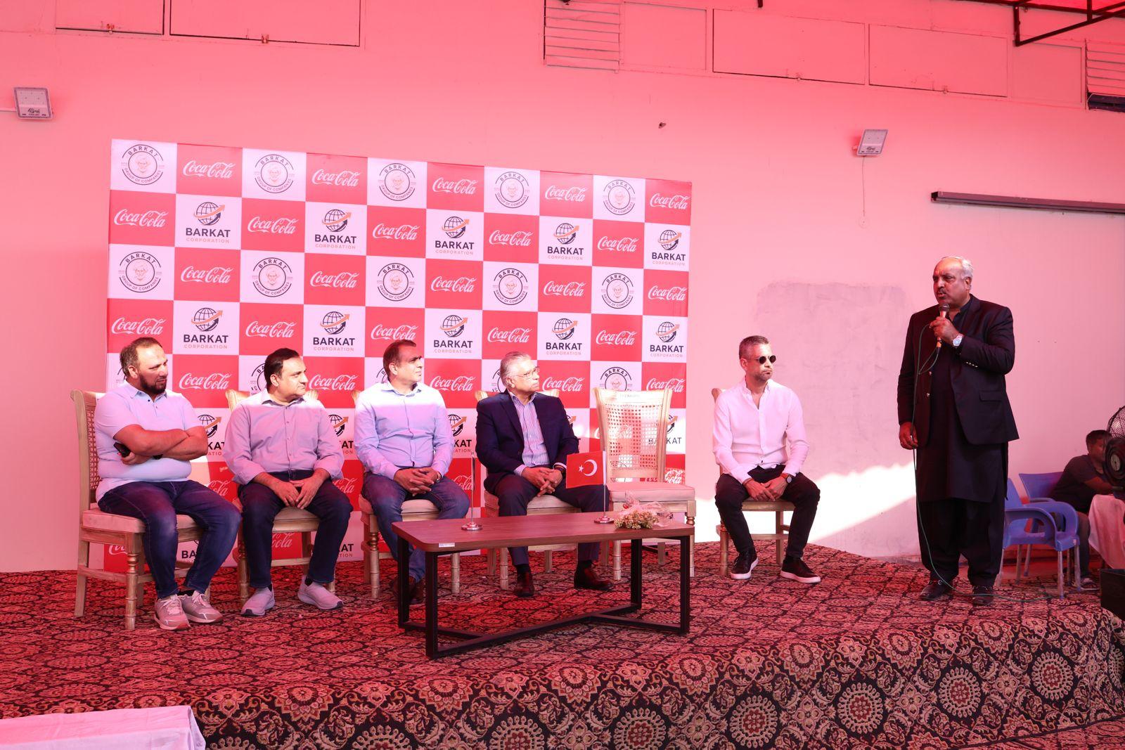 Panel discussion on stage at a Barkat Corporation Coca-Cola distribution event